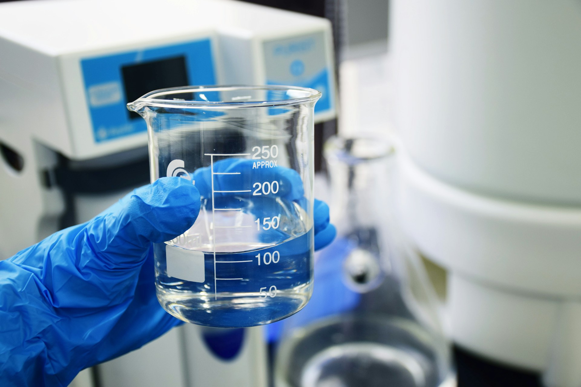 Laboratory analyst holding a glass beaker