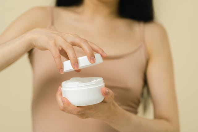 Woman showing skincare products