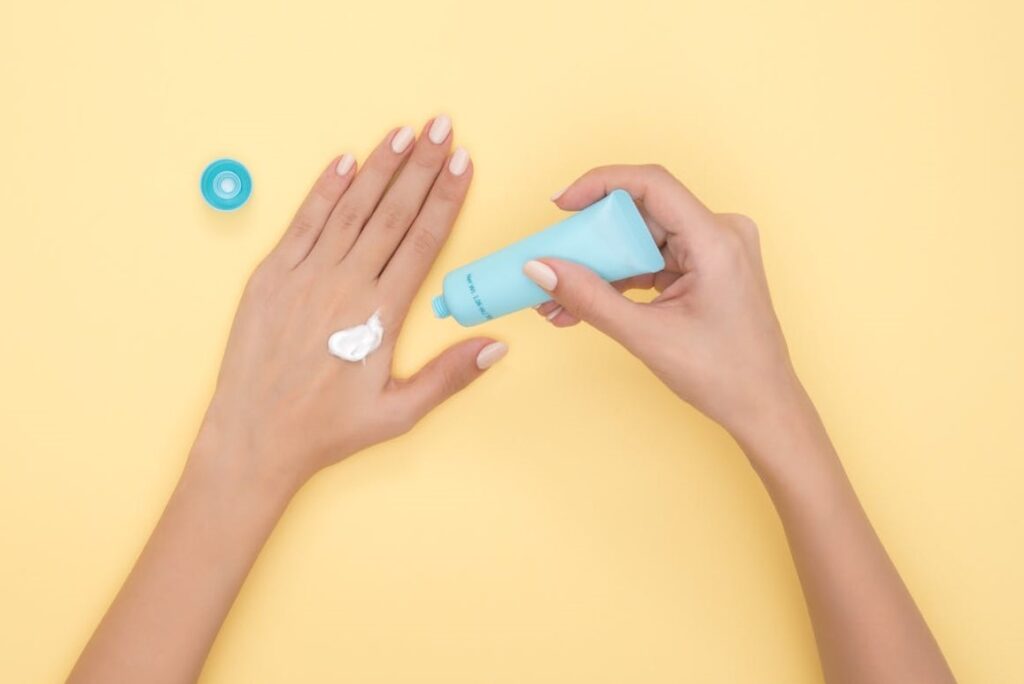 women applying cream on the hand