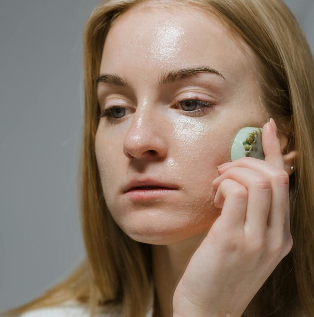 Teenager washing face with gentle foam cleanser as part of skincare routine